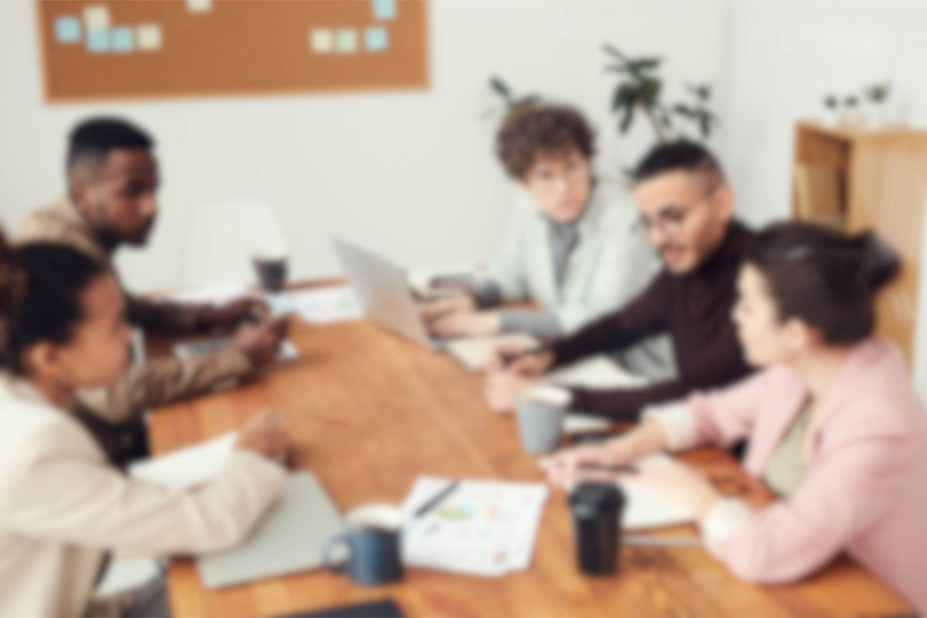 a slightly blurred image of people sitting in a work meeting